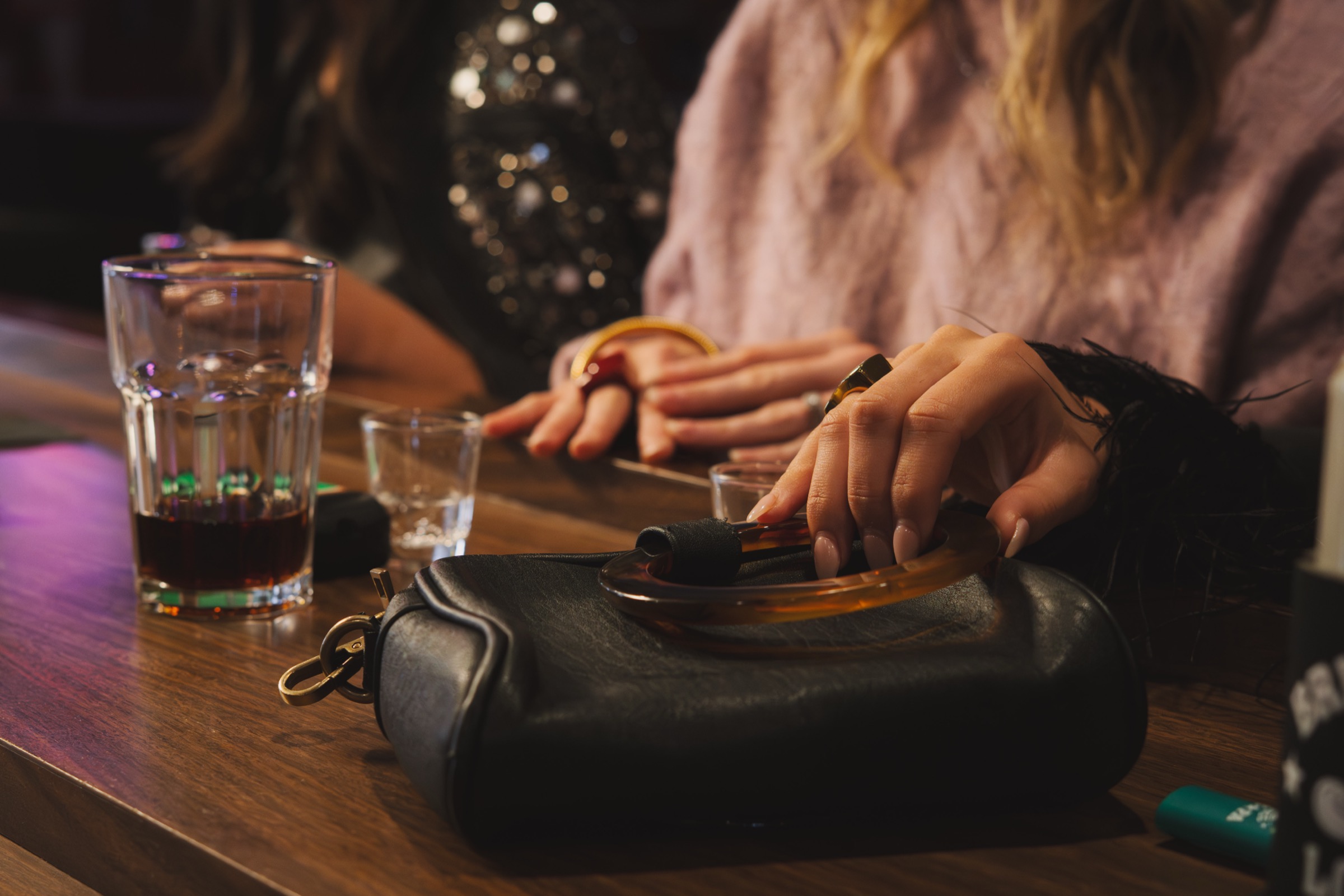 A flask, shot glasses and hands on the bar at The Brickette Lounge